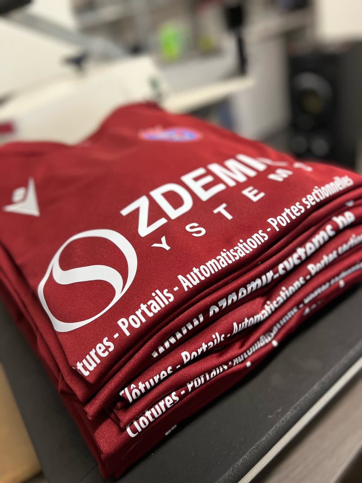 Pile de maillots rouges imprimés au logo d'un sponsor