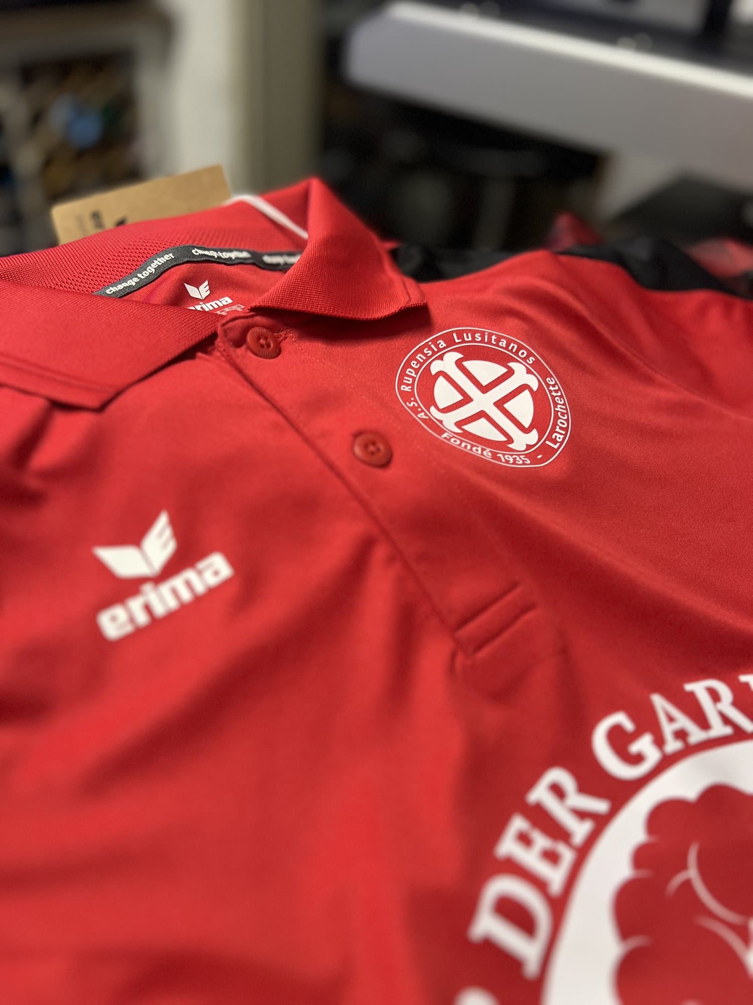 Polo de sport rouge au logo d'un club